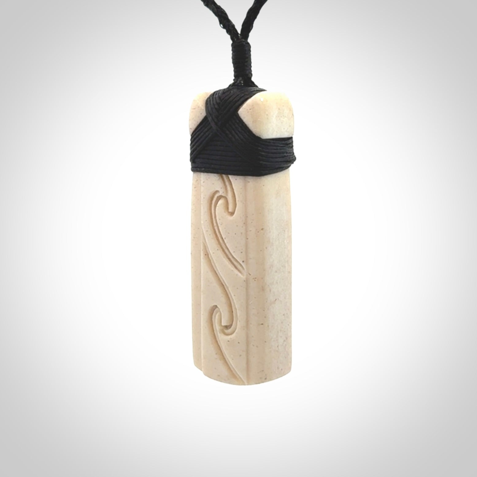 This is a wonderful, finely carved Toki pendant. It is hand carved by Andrew Doughty and we will ship it to you free anywhere in the world. Hand made from whale bone. Delivered to you with an adjustable black cord.