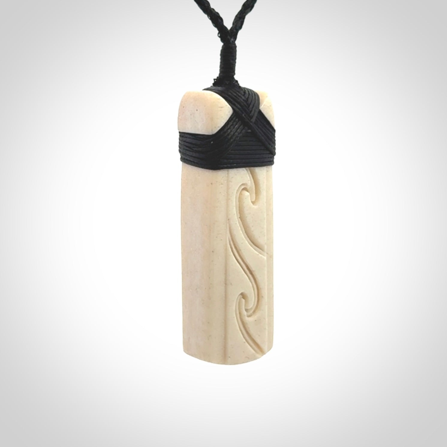 This is a wonderful, finely carved Toki pendant. It is hand carved by Andrew Doughty and we will ship it to you free anywhere in the world. Hand made from whale bone. Delivered to you with an adjustable black cord.
