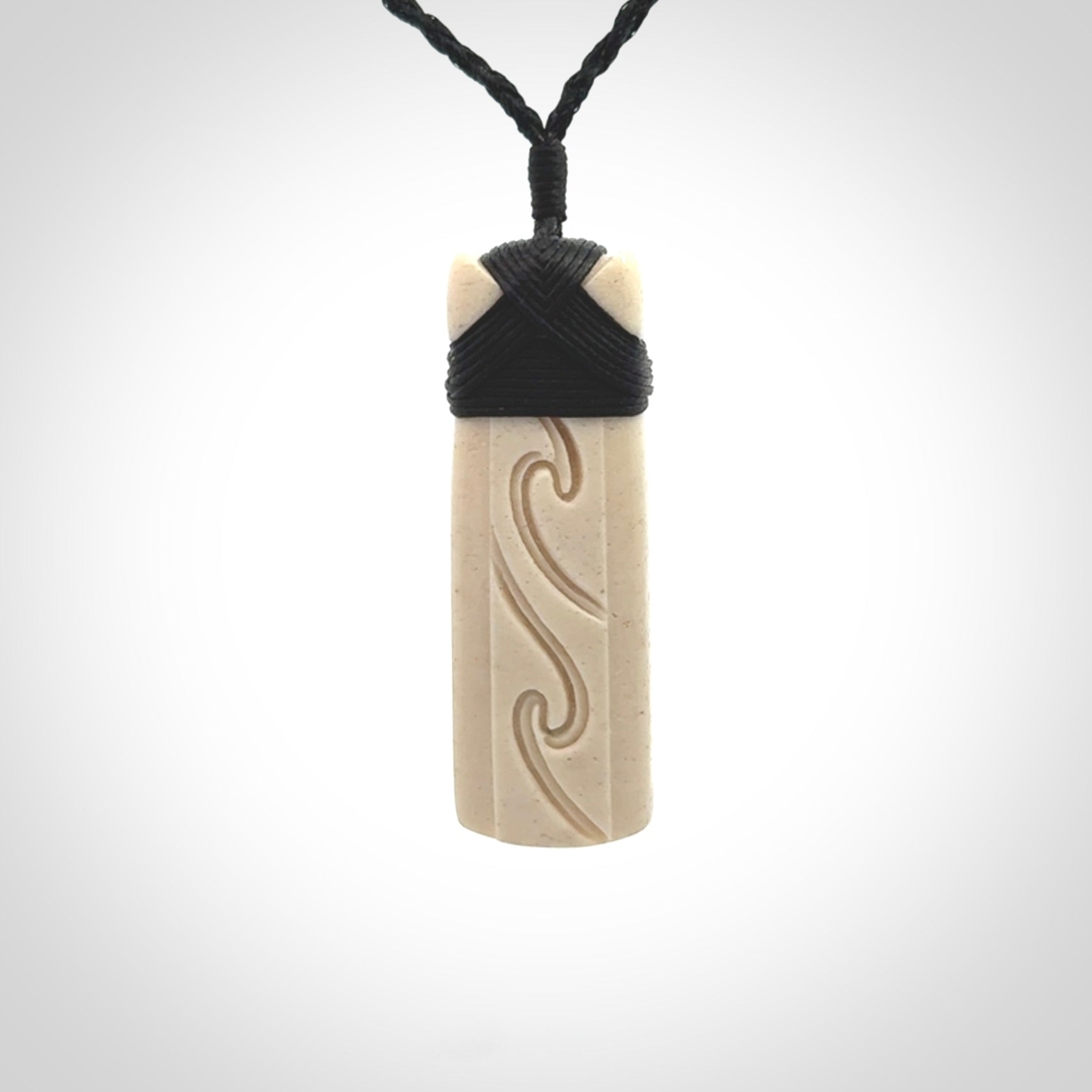 This is a wonderful, finely carved Toki pendant. It is hand carved by Andrew Doughty and we will ship it to you free anywhere in the world. Hand made from whale bone. Delivered to you with an adjustable black cord.