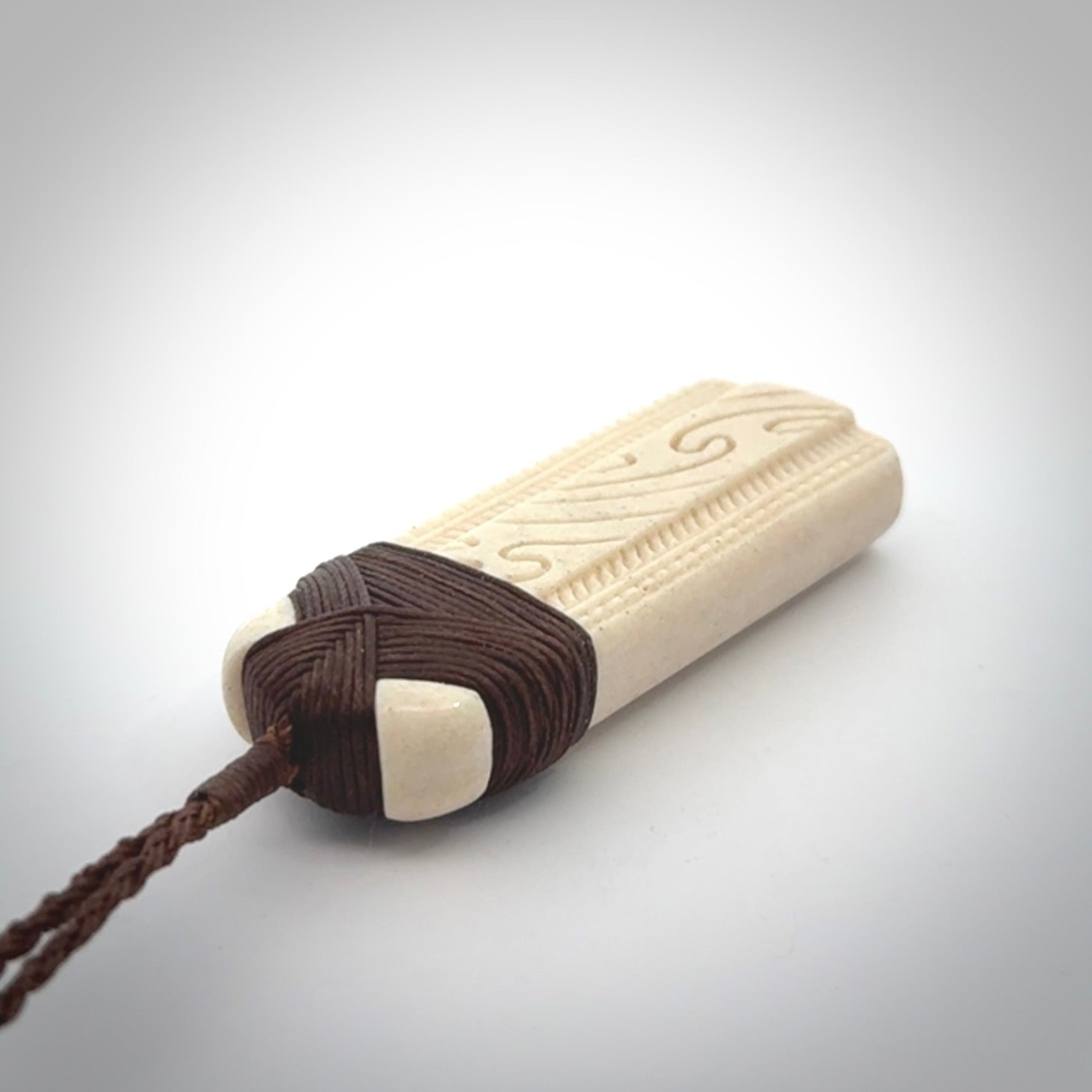 This is a wonderful whale bone toki pendant. Delivered to you with an adjustable brown cord.