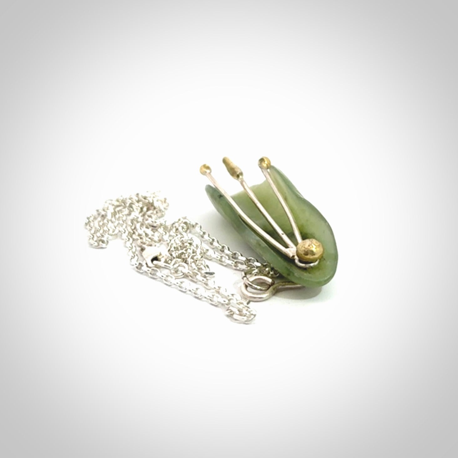 This kowhai flower drop pendant is beautifully hand made with gorgeous flair. It is fashionable and perfect for a women with style. Hand carved from a gorgeous piece of New Zealand jade with Gold leaf coating and sterling silver - this is an elegant and beautiful piece of art to wear.