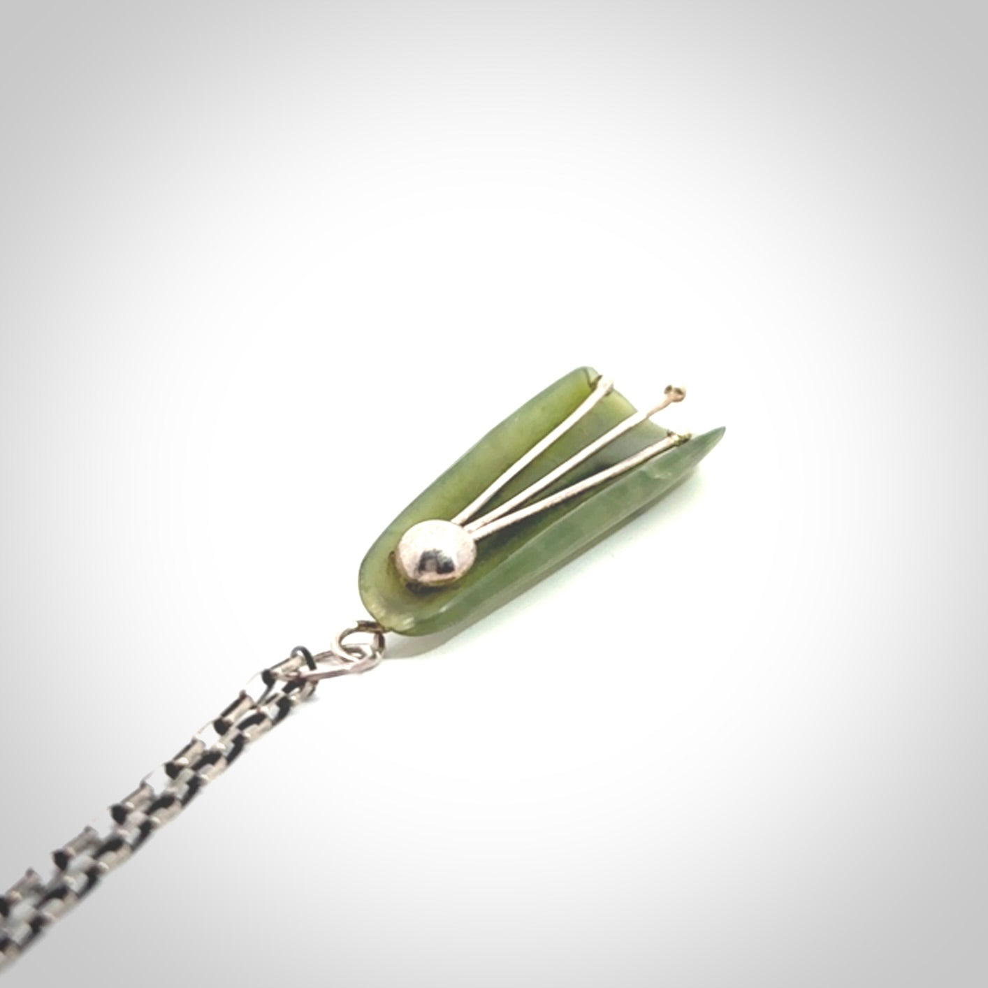 This kowhai flower drop pendant is beautifully hand made with gorgeous flair. It is fashionable and perfect for a women with style. Hand carved from a gorgeous piece of New Zealand jade with sterling silver - this is an elegant and beautiful piece of art to wear.