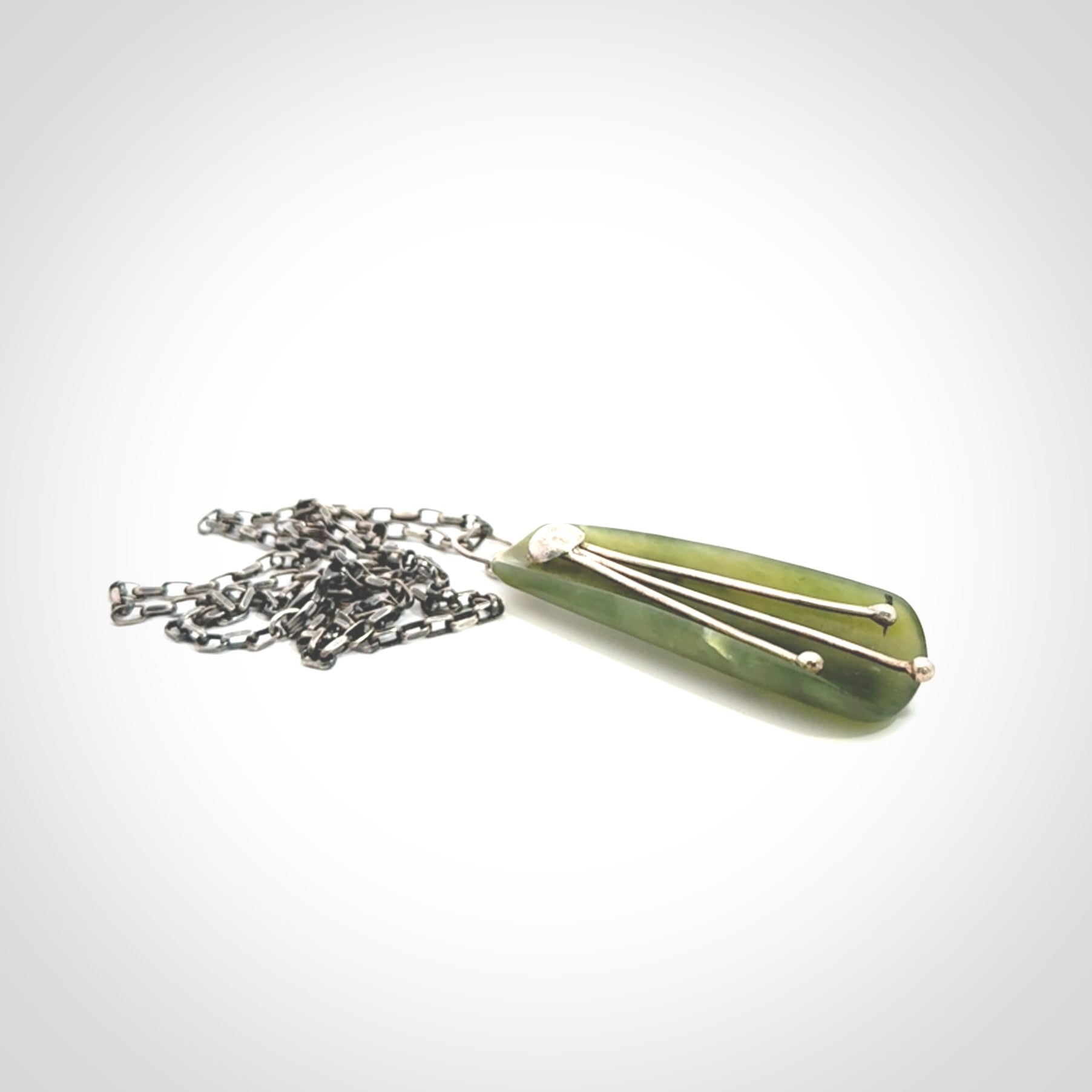 This kowhai flower drop pendant is beautifully hand made with gorgeous flair. It is fashionable and perfect for a women with style. Hand carved from a gorgeous piece of New Zealand jade with sterling silver - this is an elegant and beautiful piece of art to wear.