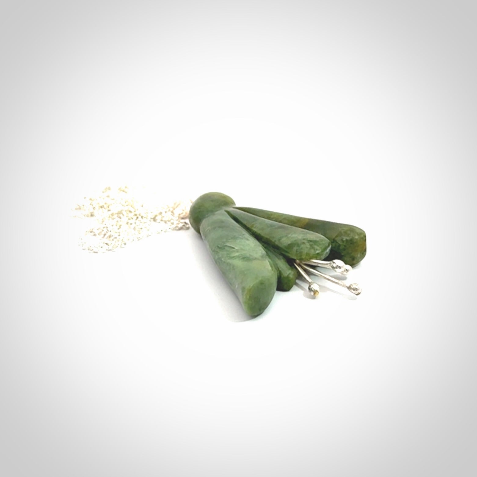 This picture shows a beautiful flower jade flower pendant with sterling silver flowers. This is a spectacular work of art and is a one off piece. Hand carved from New Zealand Flower Jade with sterling silver flowers, replicating a beautiful flower.