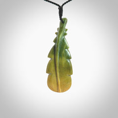 Hand carved New Zealand Flower Jade feather pendant. Made by Ana Krakosky for NZ Pacific in New Zealand Pounamu, jade. A beautiful dark green and orange jade feather drop necklace with black adjustable cord.