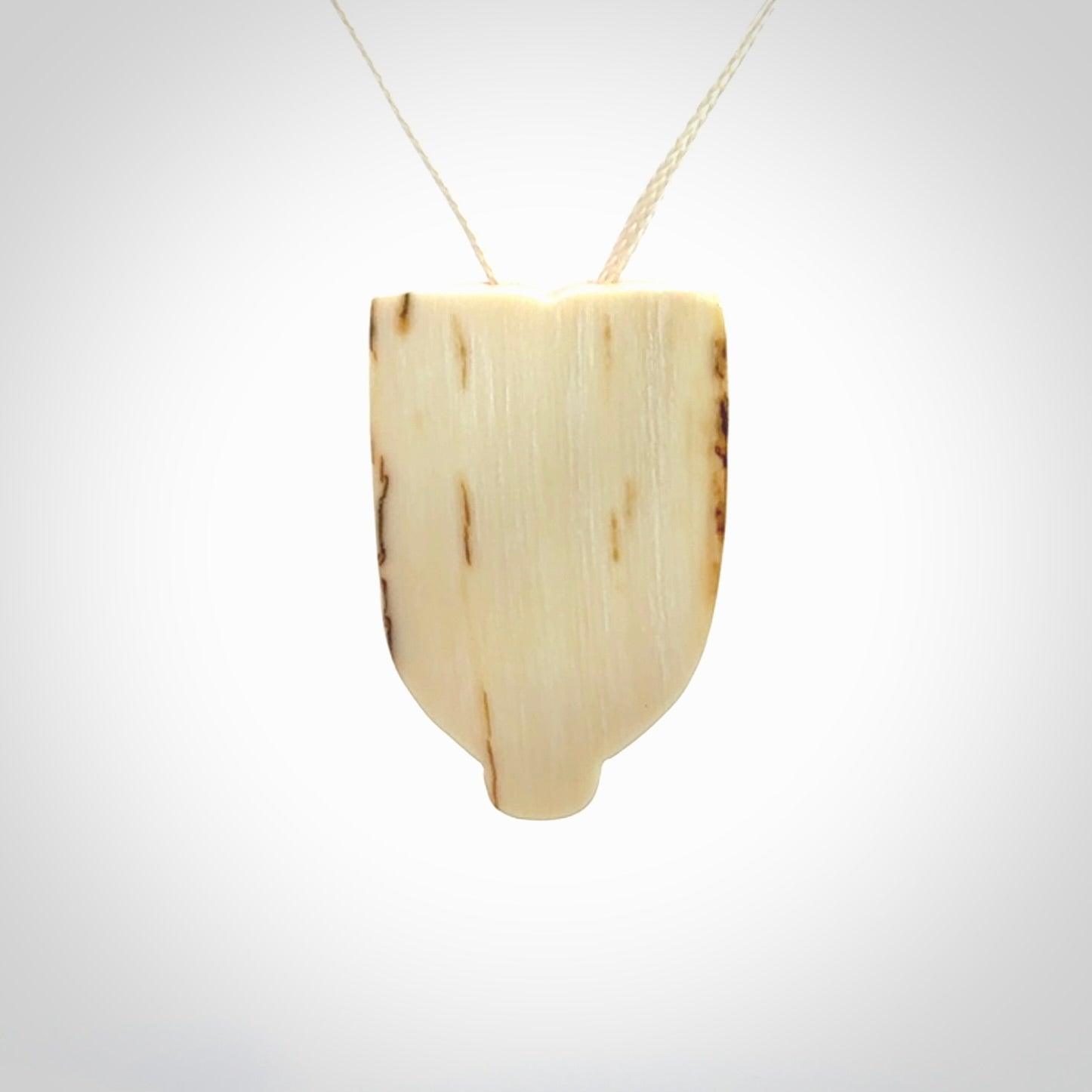 Hand carved Wheku pendant. Carved from woolly mammoth Tusk by NZ Pacific. Hand crafted Mammoth tusk jewellery for sale online. Provided with an adjustable cord and packaged in woven kete pouch.