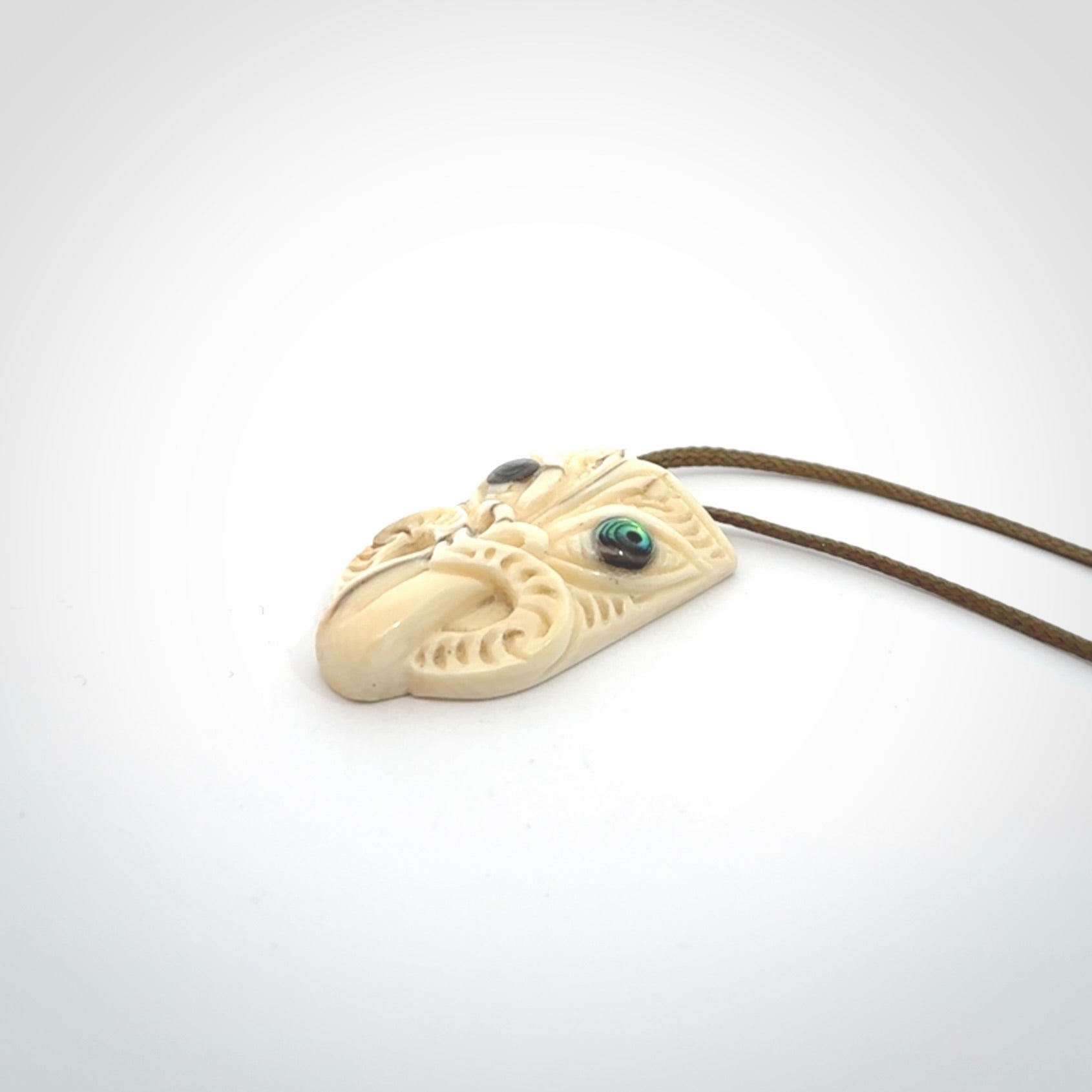 Hand carved Wheku pendant. Carved from woolly mammoth Tusk by NZ Pacific. Hand crafted Mammoth tusk jewellery for sale online. Provided with an adjustable cord and packaged in woven kete pouch.