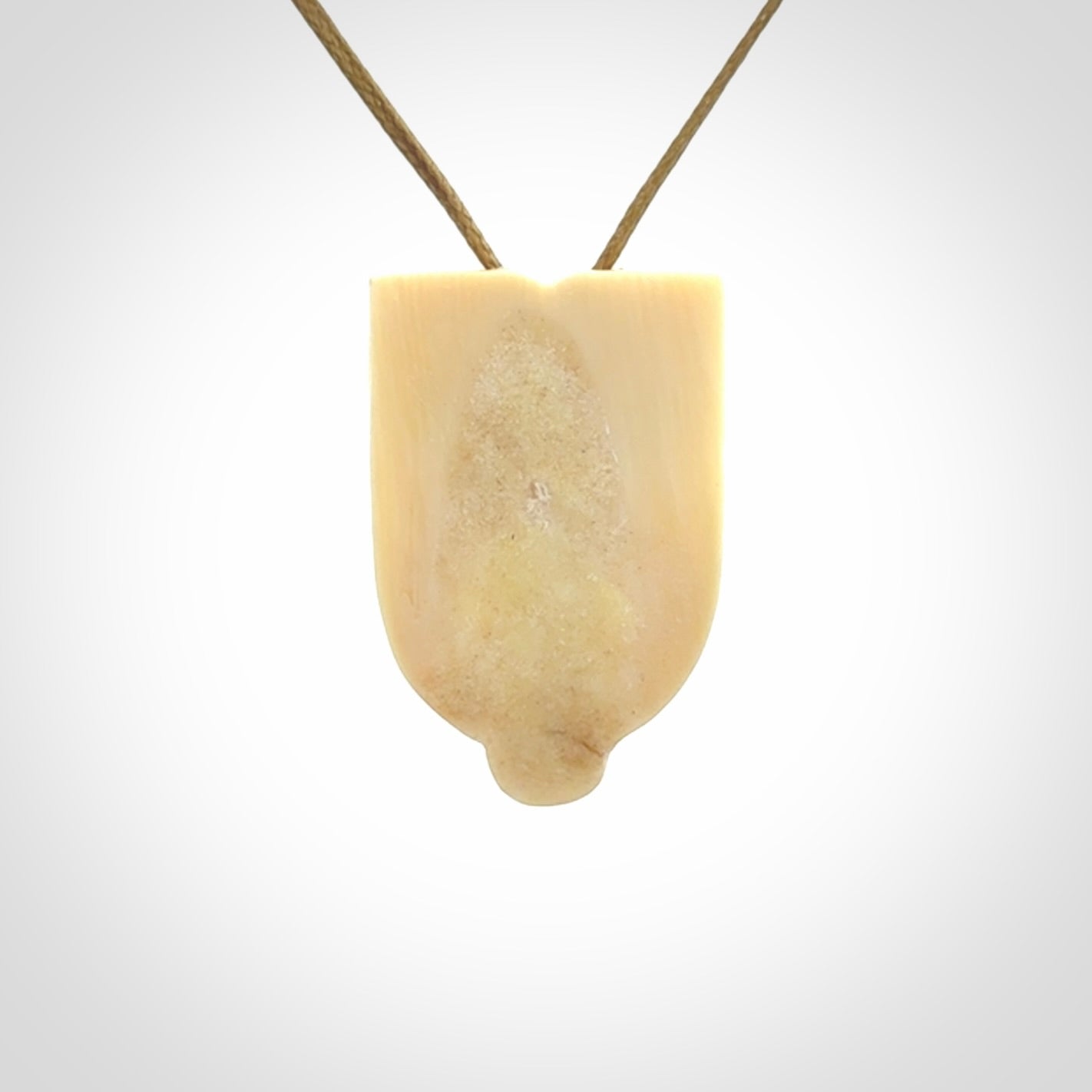 Hand carved Wheku pendant. Carved from woolly mammoth Tusk by NZ Pacific. Hand crafted Mammoth tusk jewellery for sale online. Provided with an adjustable cord and packaged in woven kete pouch.