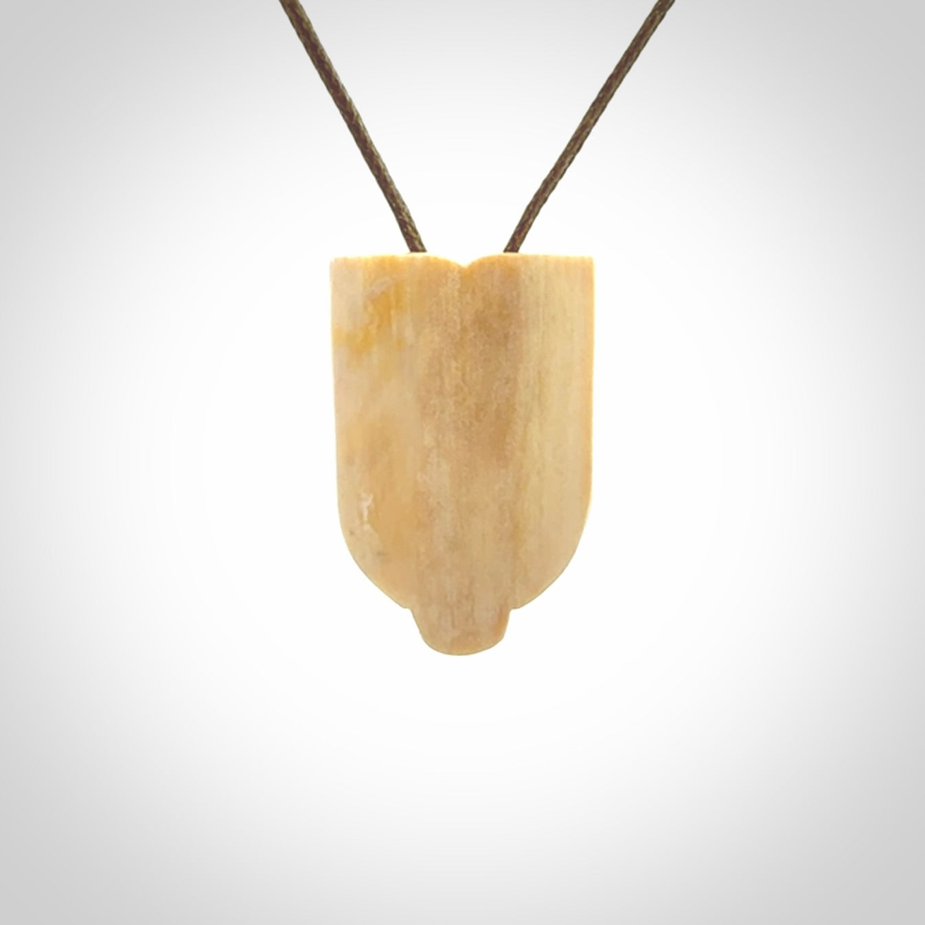 Hand carved Wheku pendant. Carved from woolly mammoth Tusk by NZ Pacific. Hand crafted Mammoth tusk jewellery for sale online. Provided with an adjustable cord and packaged in woven kete pouch.