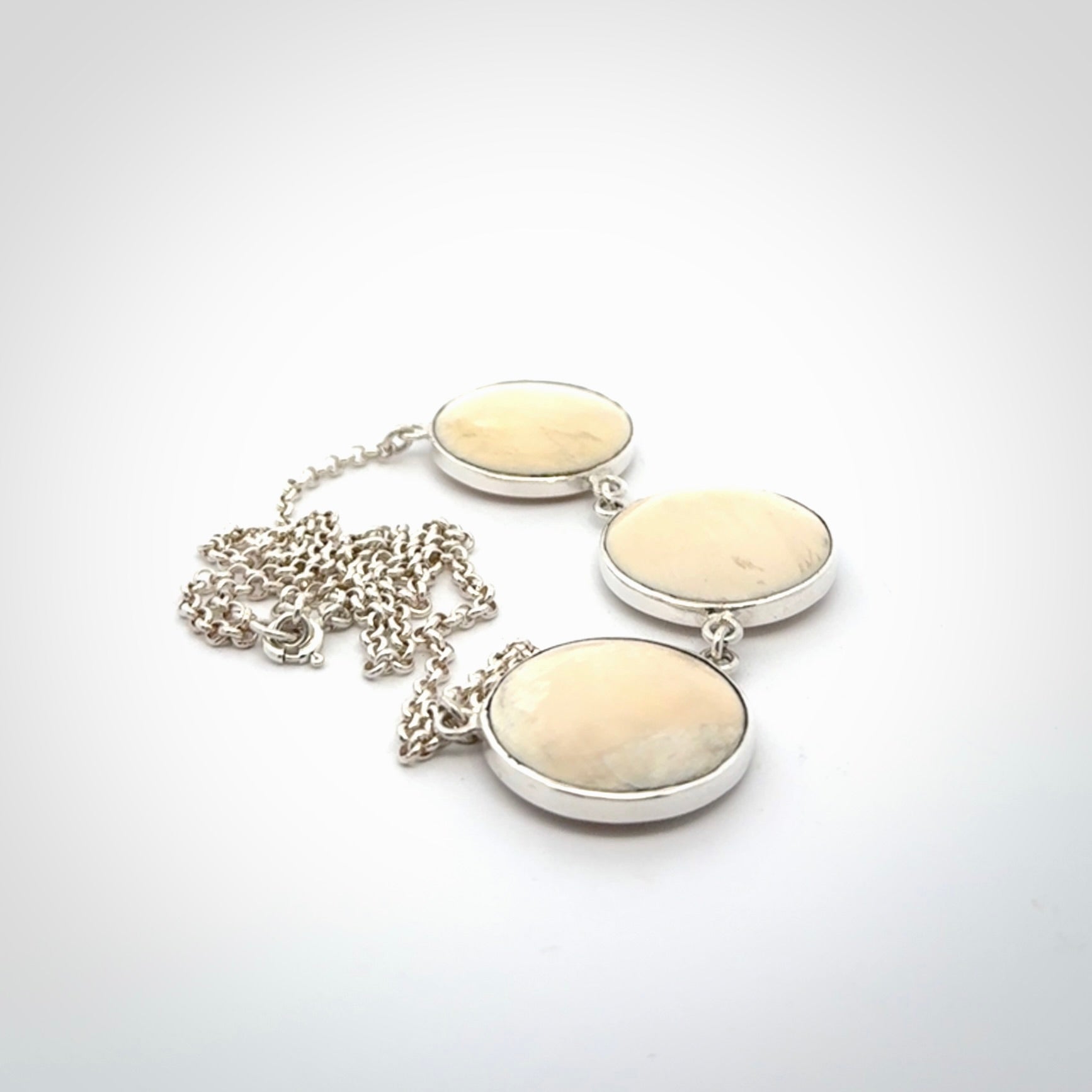 Hand made woolly mammoth tusk triple drop necklace with Sterling Silver. Mammoth tusk triple drop pendant with Sterling silver surround and chain. Made by NZ Pacific and sale online only. Packaged in a woven kete pouch and shipped to you with Express Courier.