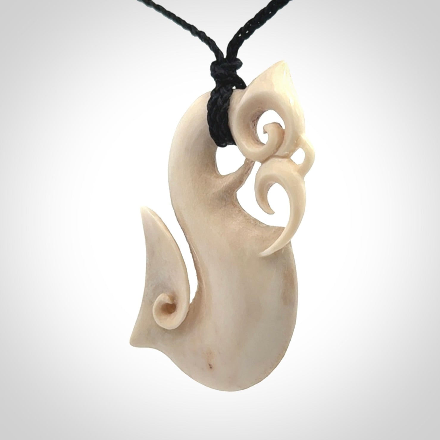 Hand made deer antler manaia pendant. Hand carved by NZ Pacific. Manaia carved from deer antler pendant for sale online. Delivered to you on an adjustable black cord and packaged in a woven kete pouch.