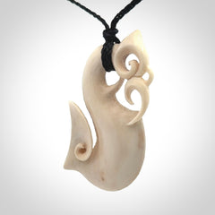 Hand made deer antler manaia pendant. Hand carved by NZ Pacific. Manaia carved from deer antler pendant for sale online. Delivered to you on an adjustable black cord and packaged in a woven kete pouch.