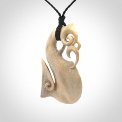 Hand made deer antler manaia pendant. Hand carved by NZ Pacific. Manaia carved from deer antler pendant for sale online. Delivered to you on an adjustable black cord and packaged in a woven kete pouch.