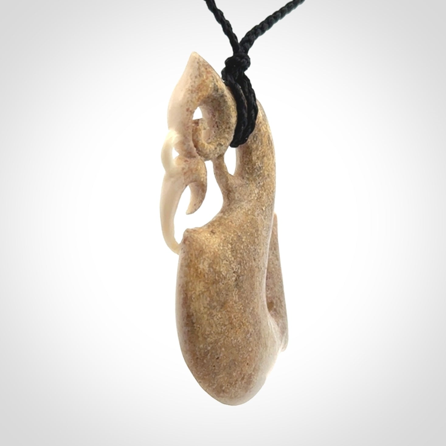 Hand made deer antler manaia pendant. Hand carved by NZ Pacific. Manaia carved from deer antler pendant for sale online. Delivered to you on an adjustable black cord and packaged in a woven kete pouch.