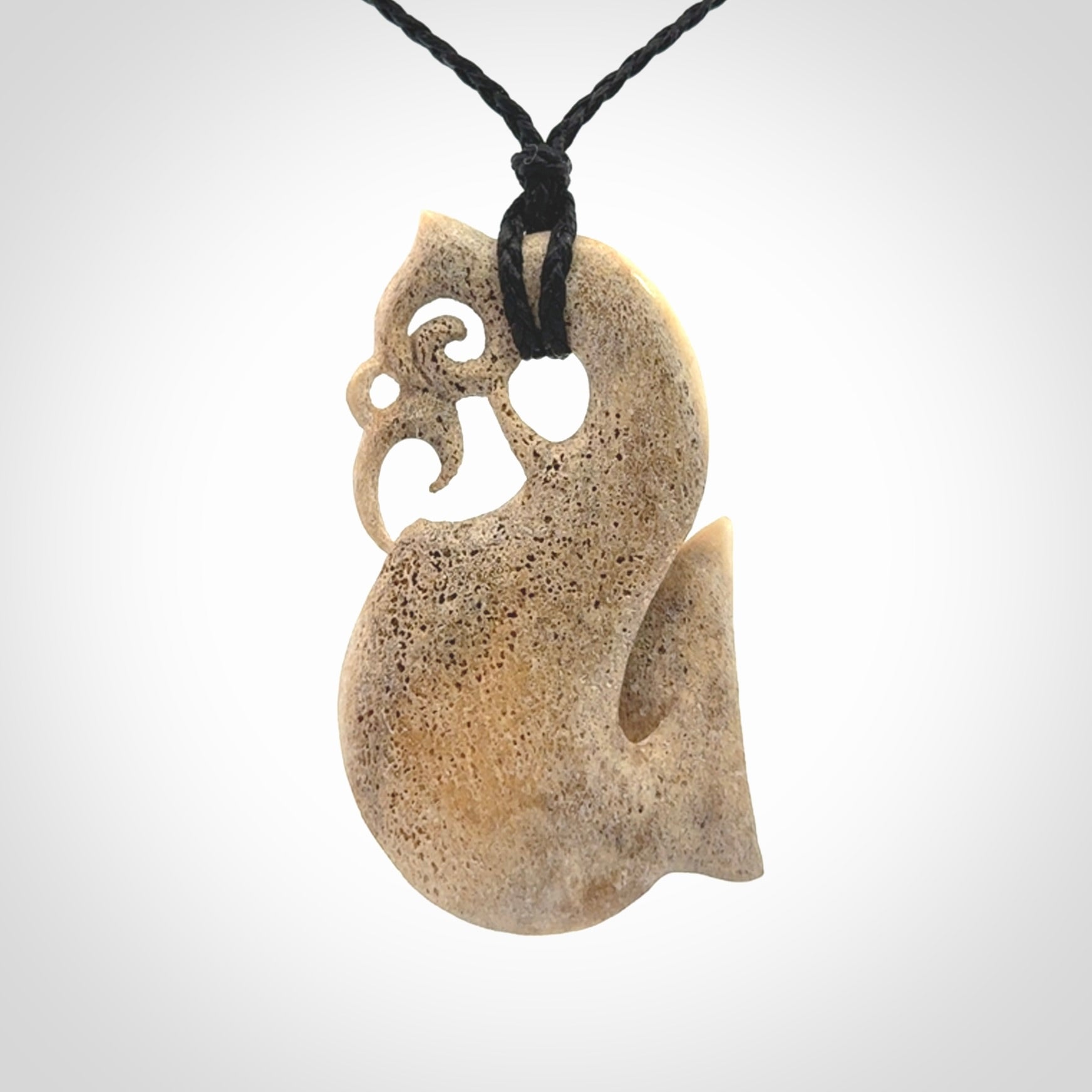Hand made deer antler manaia pendant. Hand carved by NZ Pacific. Manaia carved from deer antler pendant for sale online. Delivered to you on an adjustable black cord and packaged in a woven kete pouch.