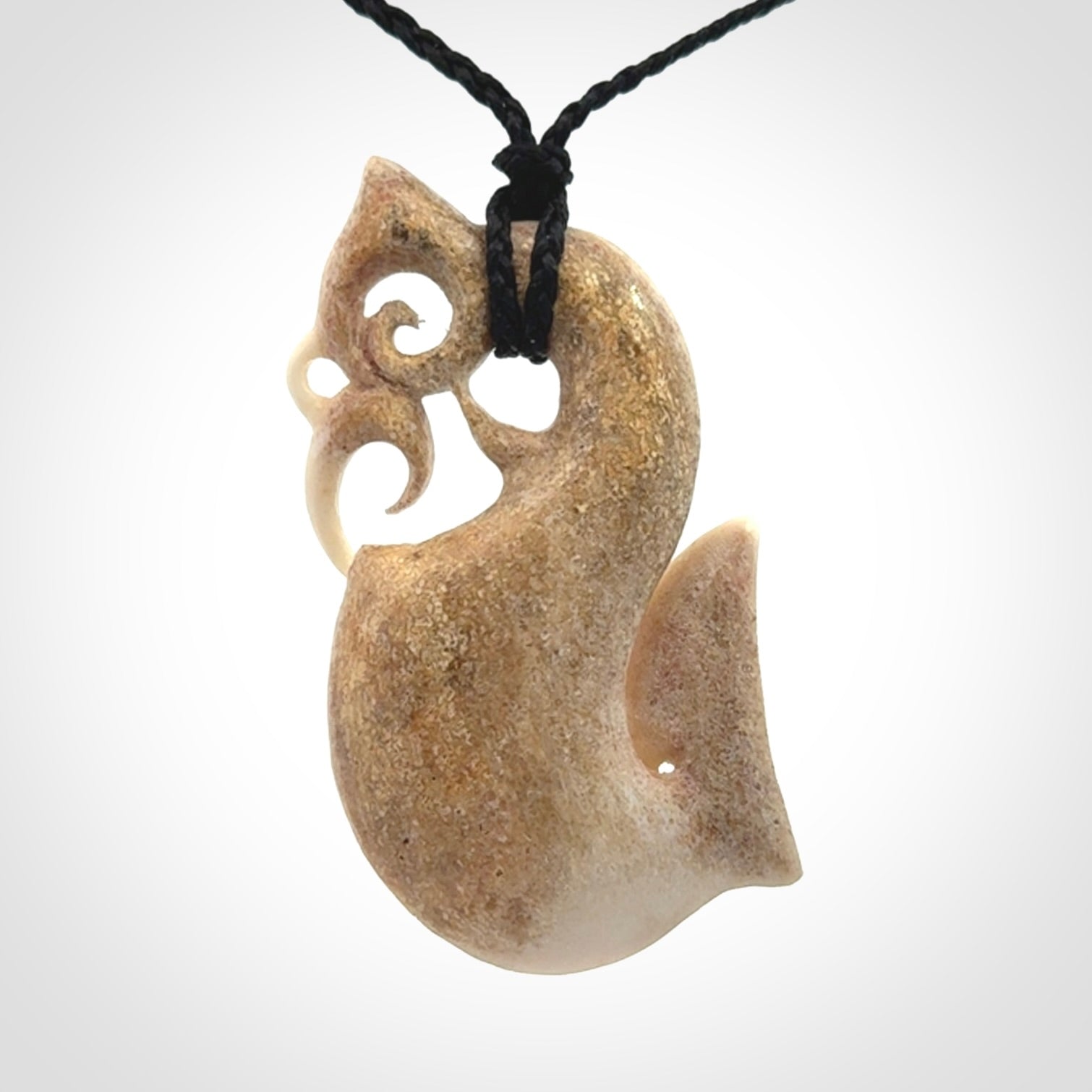 Hand made deer antler manaia pendant. Hand carved by NZ Pacific. Manaia carved from deer antler pendant for sale online. Delivered to you on an adjustable black cord and packaged in a woven kete pouch.