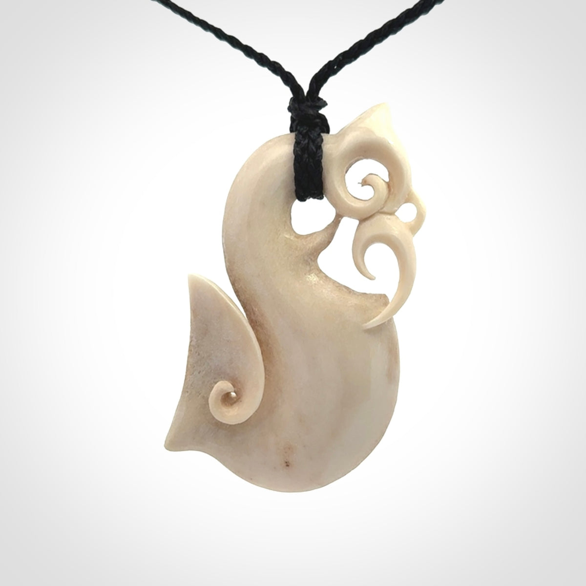 Hand made deer antler manaia pendant. Hand carved by NZ Pacific. Manaia carved from deer antler pendant for sale online. Delivered to you on an adjustable black cord and packaged in a woven kete pouch.