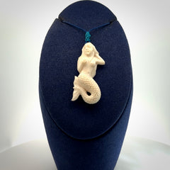 Hand carved natural bone mermaid pendant. Hand made from real bone. Art to wear. Provided with adjustable cord and packaged in a woven kete pouch.
