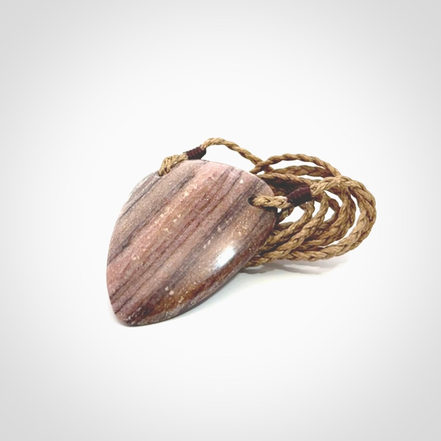 A hand carved drop pendant made from New Zealand Aroha Stone. This is a medium sized and visually striking piece, beautifully curved and sensuous. The perfect piece of jewellery for someone you love.