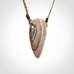 A hand carved drop pendant made from New Zealand Aroha Stone. This is a medium sized and visually striking piece, beautifully curved and sensuous. The perfect piece of jewellery for someone you love.