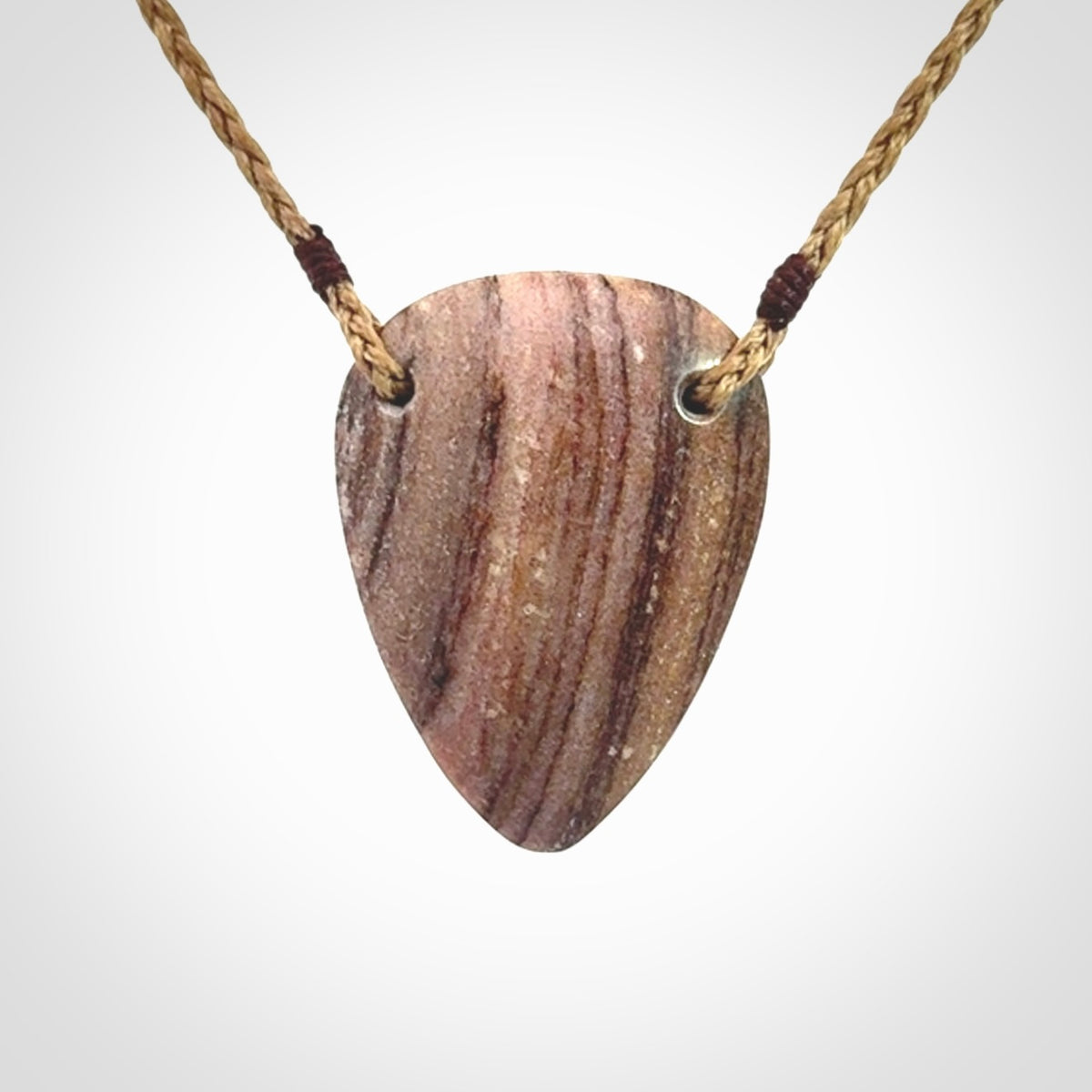A hand carved drop pendant made from New Zealand Aroha Stone. This is a medium sized and visually striking piece, beautifully curved and sensuous. The perfect piece of jewellery for someone you love.