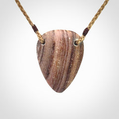 A hand carved drop pendant made from New Zealand Aroha Stone. This is a medium sized and visually striking piece, beautifully curved and sensuous. The perfect piece of jewellery for someone you love.