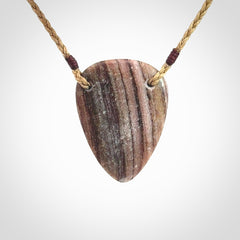 A hand carved drop pendant made from New Zealand Aroha Stone. This is a medium sized and visually striking piece, beautifully curved and sensuous. The perfect piece of jewellery for someone you love.