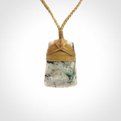 This is a handcrafted aotea stone Toki pendant.