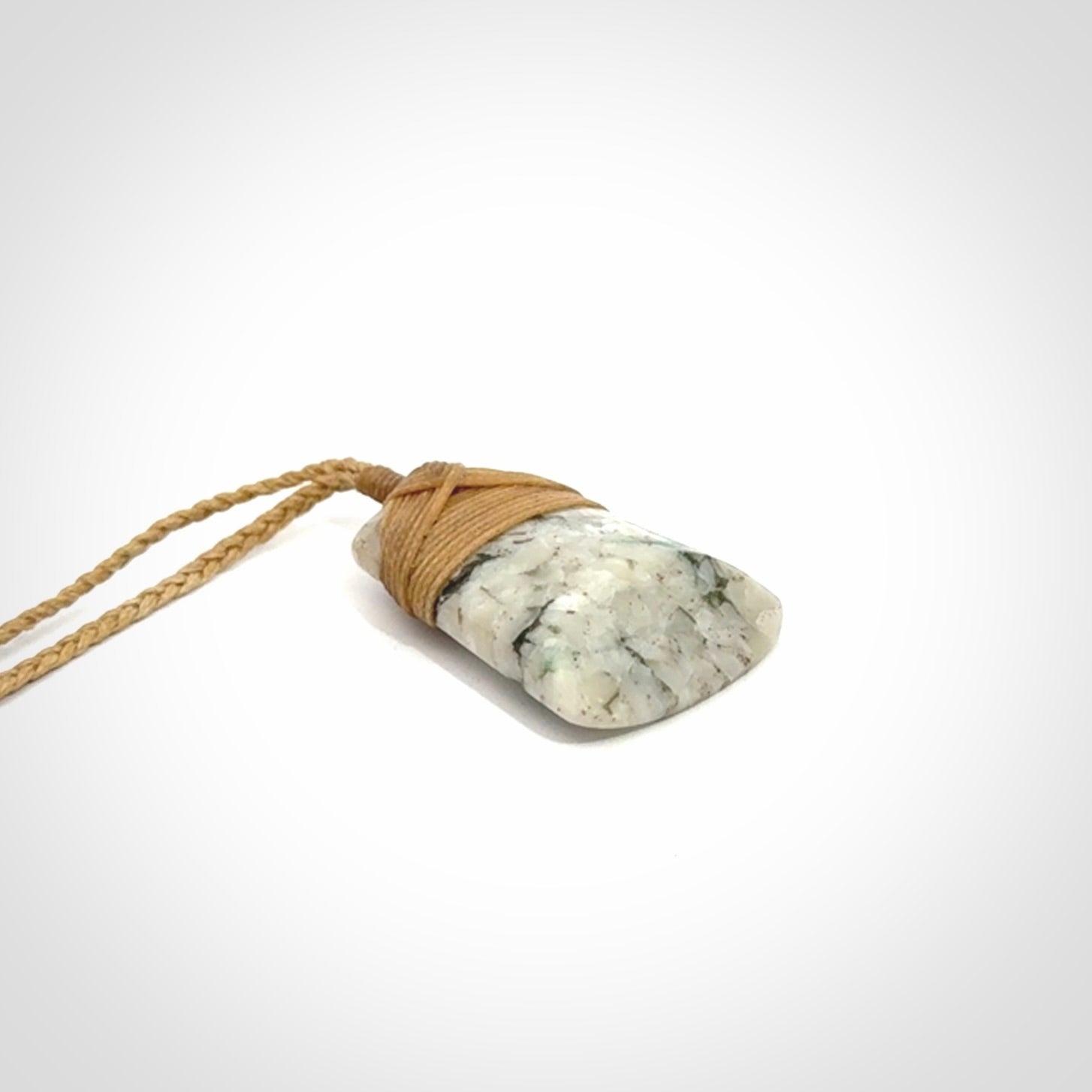 This is a handcrafted aotea stone Toki pendant.