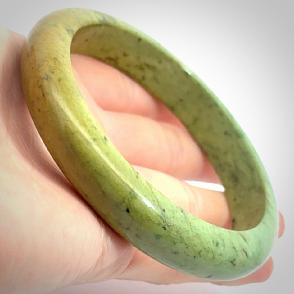 New Zealand flower jade bangle. This is carved from a solid piece of jade and polished to a mirror finish on the outside. The inside is a satin finish. The jade is high grade New Zealand Marsden and is a beautiful coloured stone.