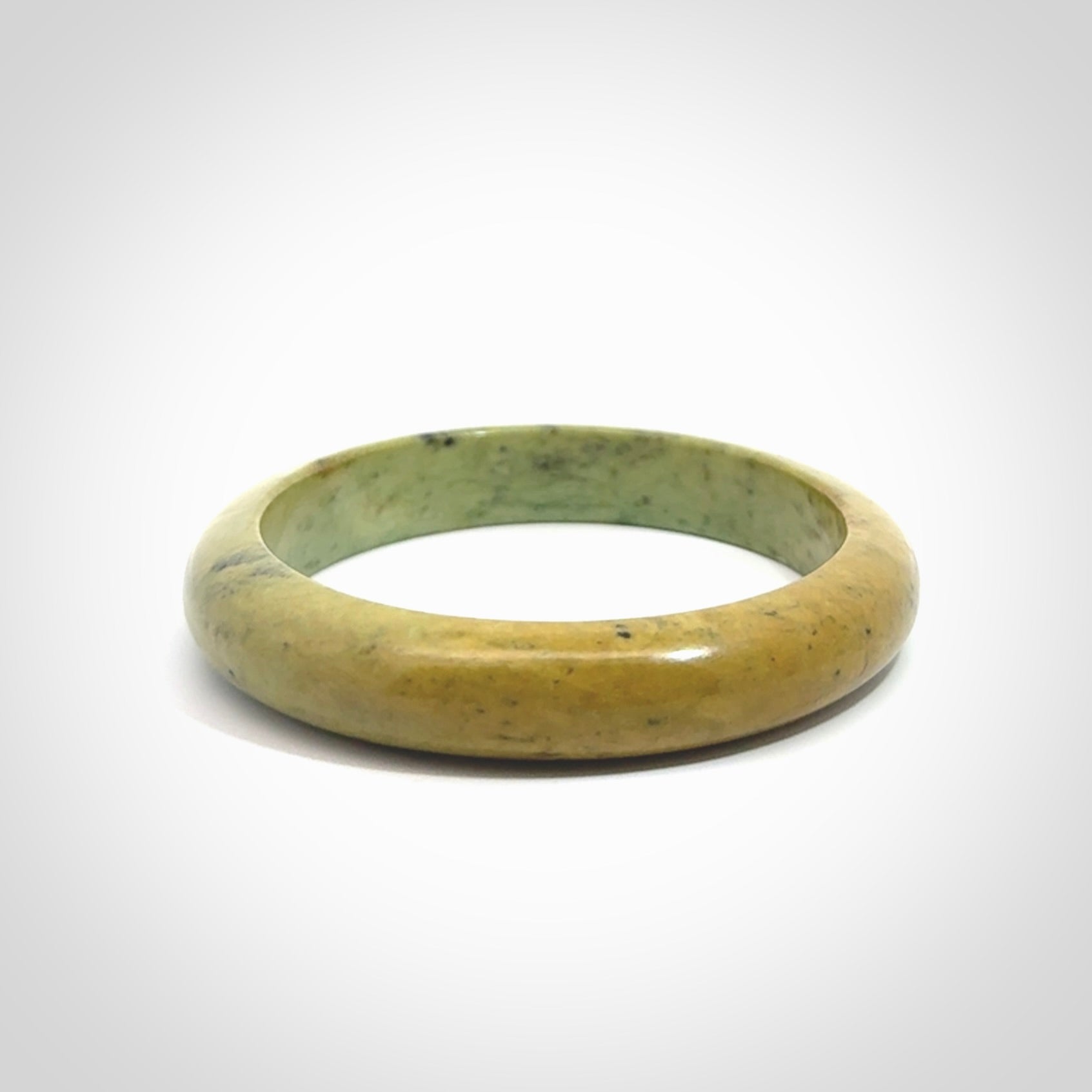 New Zealand flower jade bangle. This is carved from a solid piece of jade and polished to a mirror finish on the outside. The inside is a satin finish. The jade is high grade New Zealand Marsden and is a beautiful coloured stone.