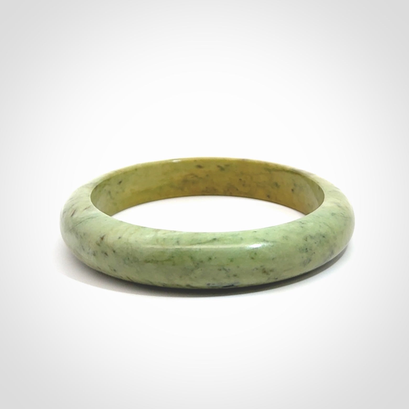 New Zealand flower jade bangle. This is carved from a solid piece of jade and polished to a mirror finish on the outside. The inside is a satin finish. The jade is high grade New Zealand Marsden and is a beautiful coloured stone.