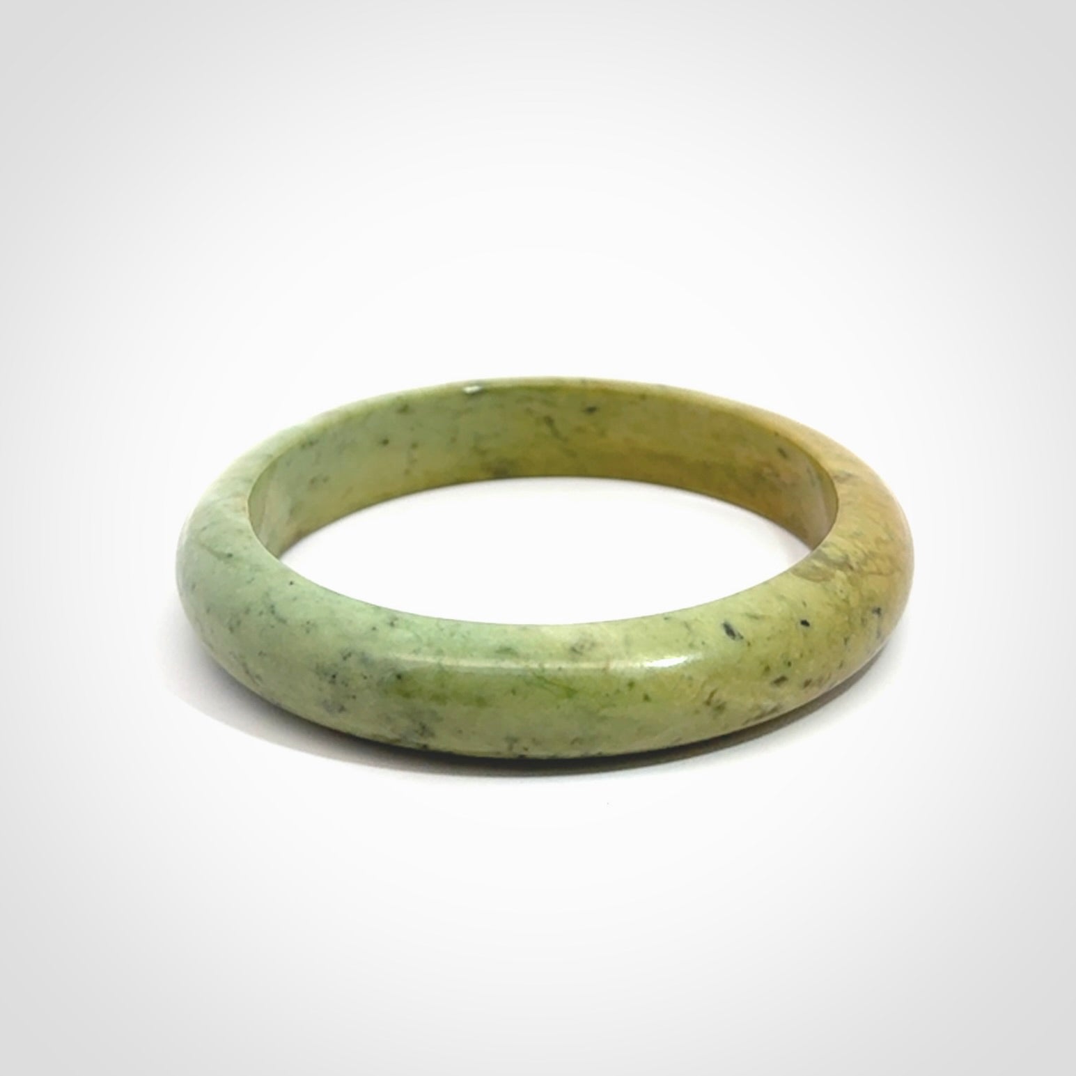 New Zealand flower jade bangle. This is carved from a solid piece of jade and polished to a mirror finish on the outside. The inside is a satin finish. The jade is high grade New Zealand Marsden and is a beautiful coloured stone.