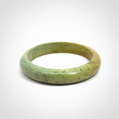 New Zealand flower jade bangle. This is carved from a solid piece of jade and polished to a mirror finish on the outside. The inside is a satin finish. The jade is high grade New Zealand Marsden and is a beautiful coloured stone.