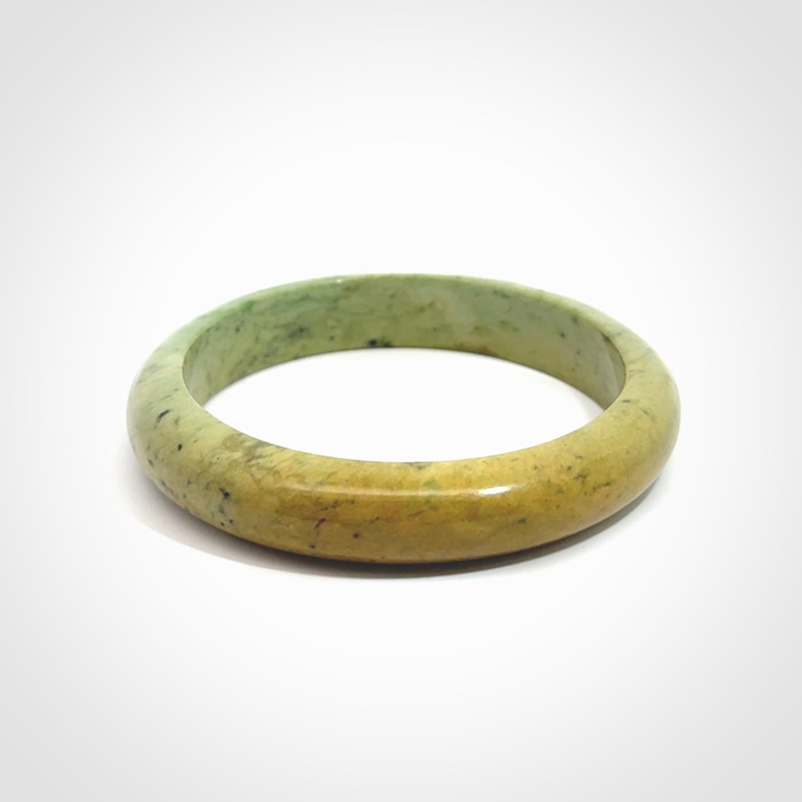 New Zealand flower jade bangle. This is carved from a solid piece of jade and polished to a mirror finish on the outside. The inside is a satin finish. The jade is high grade New Zealand Marsden and is a beautiful coloured stone.