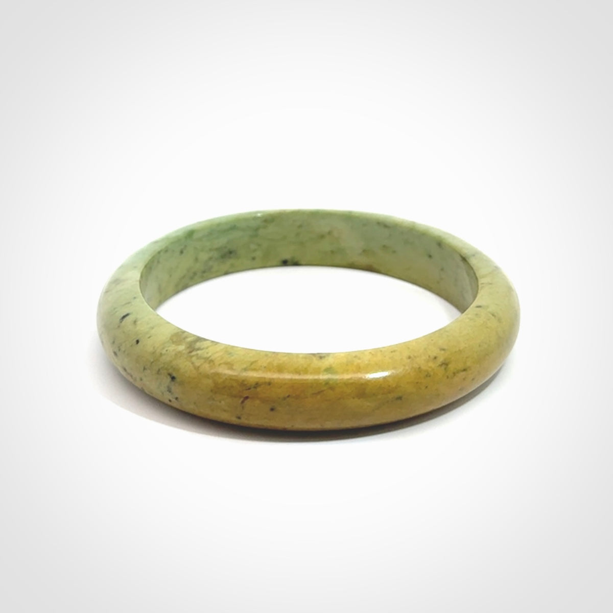New Zealand flower jade bangle. This is carved from a solid piece of jade and polished to a mirror finish on the outside. The inside is a satin finish. The jade is high grade New Zealand Marsden and is a beautiful coloured stone.