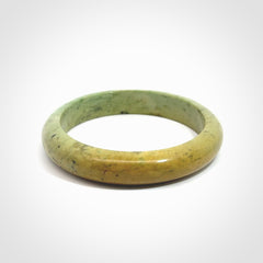 New Zealand flower jade bangle. This is carved from a solid piece of jade and polished to a mirror finish on the outside. The inside is a satin finish. The jade is high grade New Zealand Marsden and is a beautiful coloured stone.