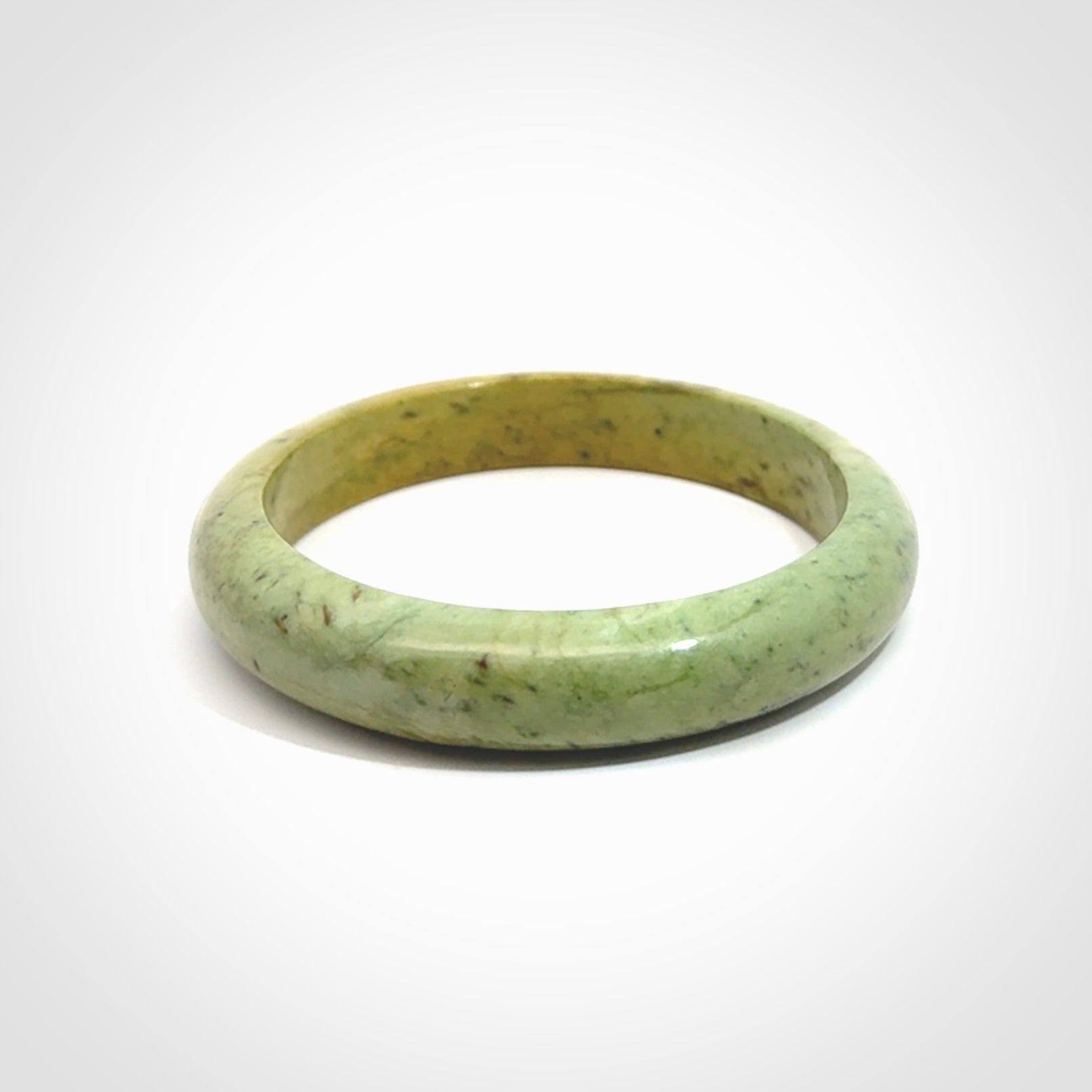 New Zealand flower jade bangle. This is carved from a solid piece of jade and polished to a mirror finish on the outside. The inside is a satin finish. The jade is high grade New Zealand Marsden and is a beautiful coloured stone.