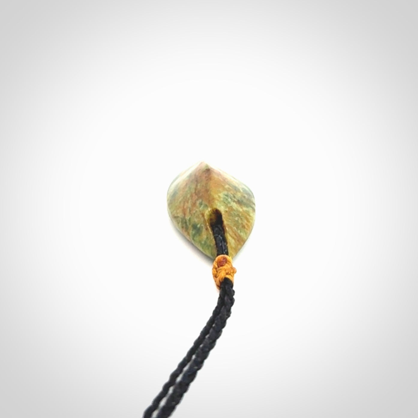 This picture shows a medium sized Flower Jade teardrop pendant. The pendant looks like a teardrop . A hand made unique and contemporary necklace hand carved here in New Zealand.