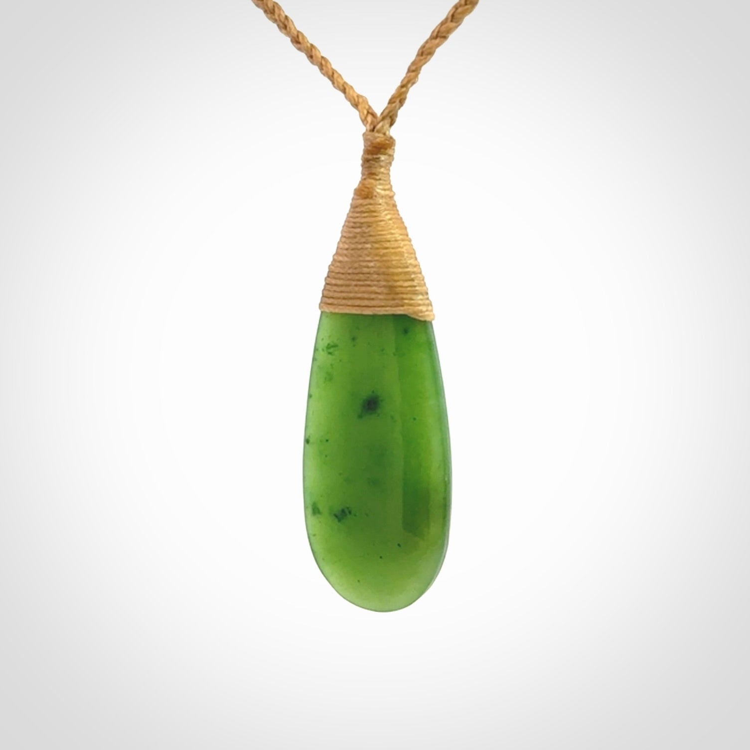 This picture shows a beautiful medium sized drop pendant carved in New Zealand Jade, pounamu. It is a lovely semi-translucent green colour, which is glows when held to the light. A gorgeous and very meaningful pendant with an adjustable cord.