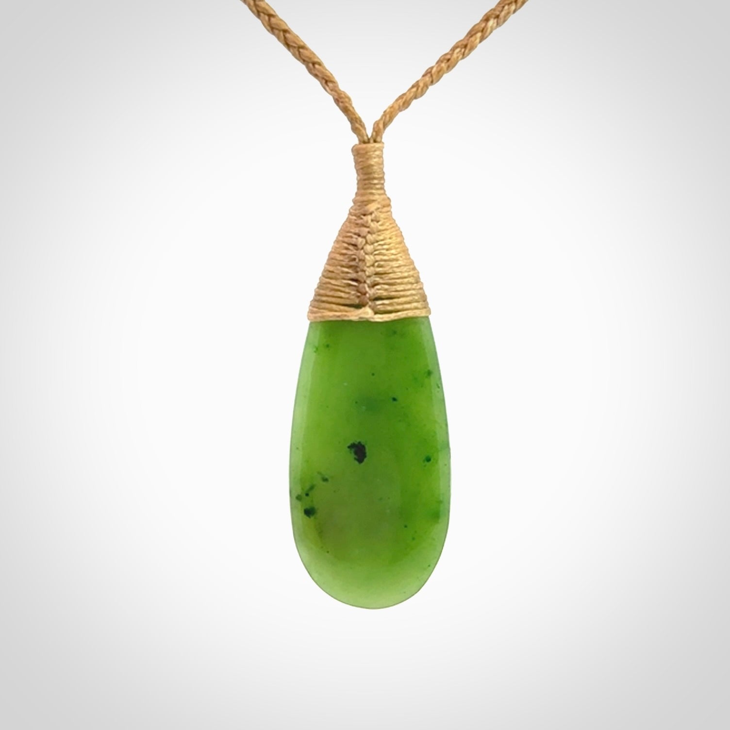 This picture shows a beautiful medium sized drop pendant carved in New Zealand Jade, pounamu. It is a lovely semi-translucent green colour, which is glows when held to the light. A gorgeous and very meaningful pendant with an adjustable cord.