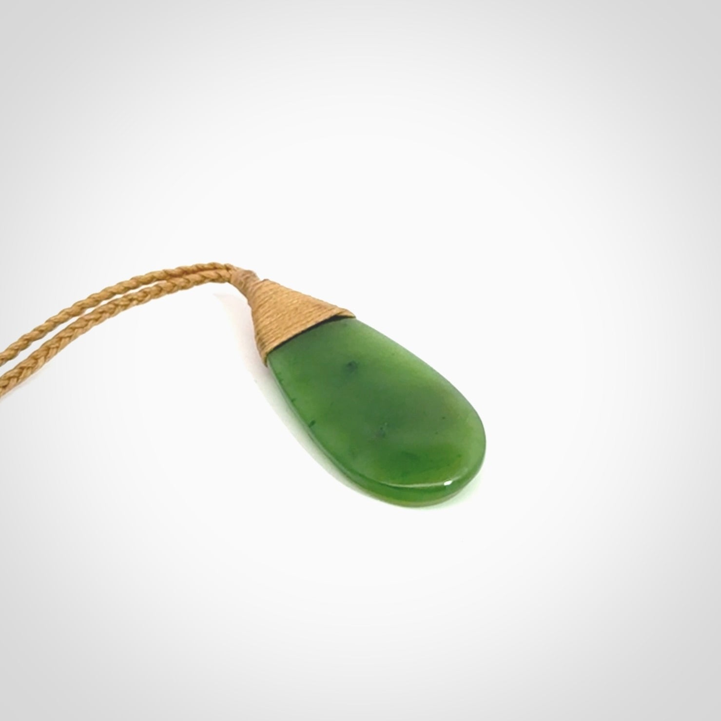 This picture shows a beautiful medium sized drop pendant carved in New Zealand Jade, pounamu. It is a lovely semi-translucent green colour, which is glows when held to the light. A gorgeous and very meaningful pendant with an adjustable cord.