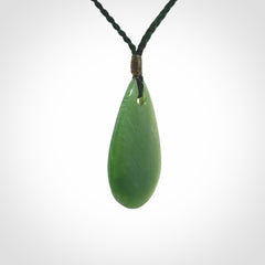 This picture shows a beautiful small sized drop pendant carved in New Zealand Jade, pounamu. It is a lovely semi-translucent green colour, which is glows when held to the light. A gorgeous and very meaningful pendant with an adjustable cord.