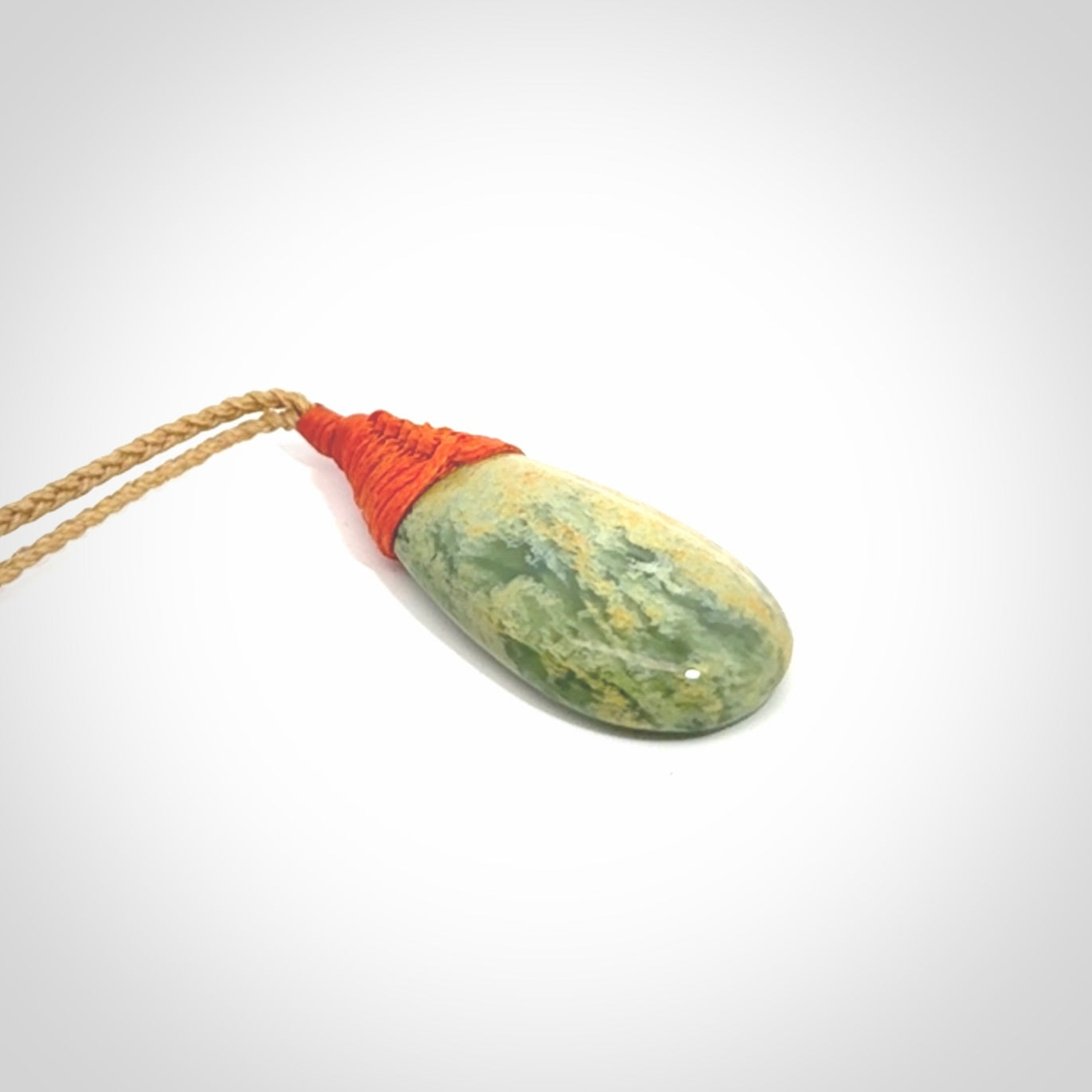 This picture shows a beautiful medium sized drop pendant carved in New Zealand Jade, pounamu. It is a lovely green and yellow colour. A gorgeous and very meaningful pendant with an adjustable cord.