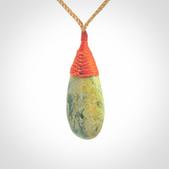This picture shows a beautiful medium sized drop pendant carved in New Zealand Jade, pounamu. It is a lovely green and yellow colour. A gorgeous and very meaningful pendant with an adjustable cord.