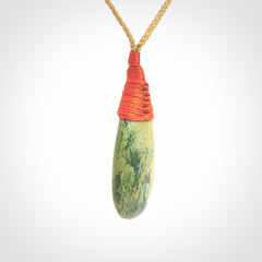 This picture shows a beautiful medium sized drop pendant carved in New Zealand Jade, pounamu. It is a lovely green and yellow colour. A gorgeous and very meaningful pendant with an adjustable cord.