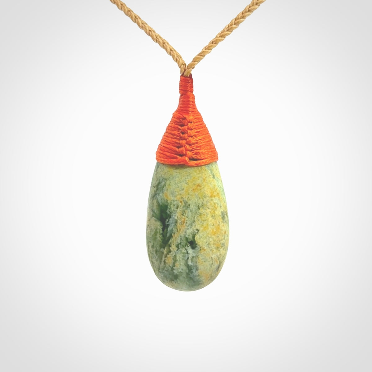 This picture shows a beautiful medium sized drop pendant carved in New Zealand Jade, pounamu. It is a lovely green and yellow colour. A gorgeous and very meaningful pendant with an adjustable cord.
