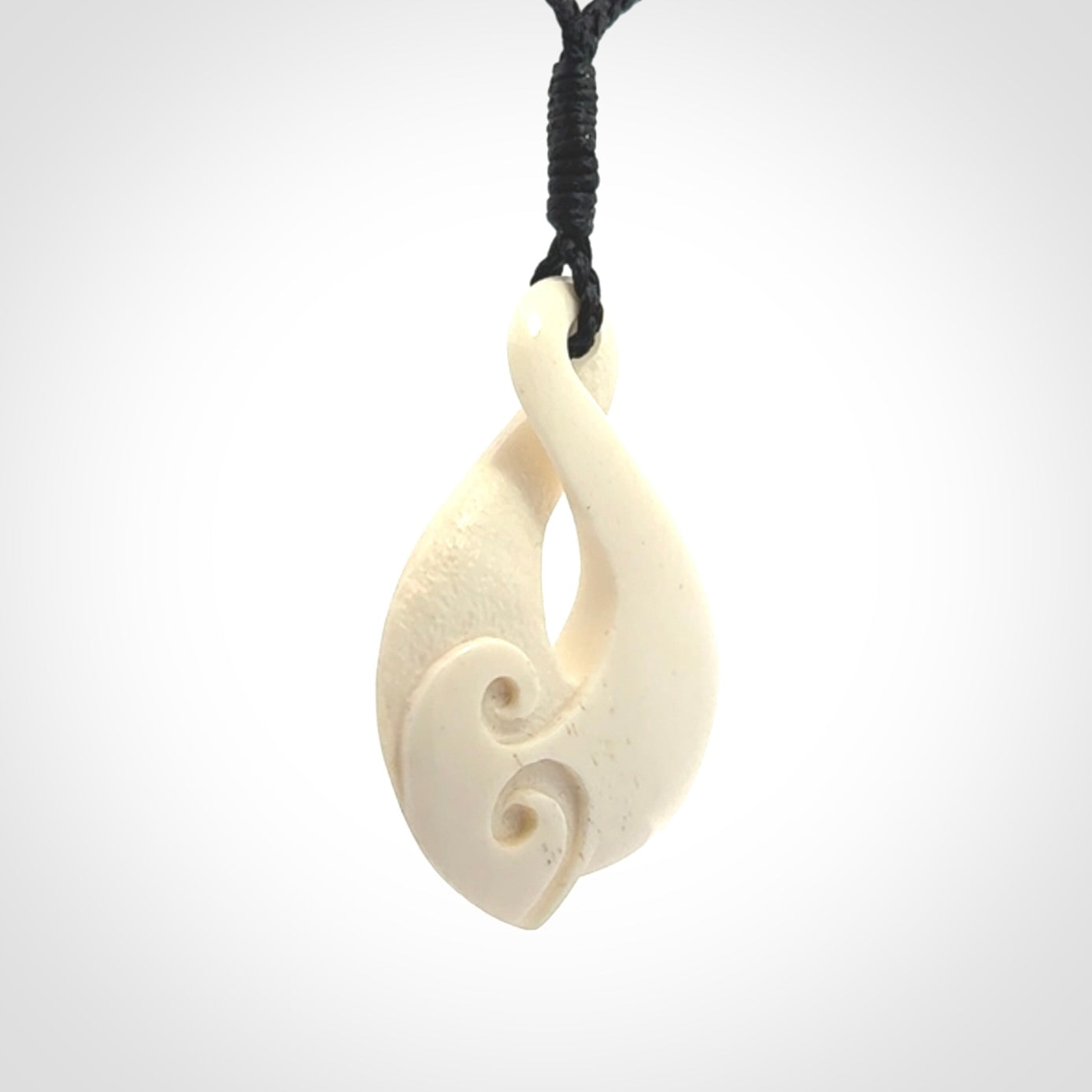 Hand carved bone twist pendant hand made by Peter Mitchell in New Zealand. This bone twist is provided with an adjustable black cord and packaged in a woven kete pouch.