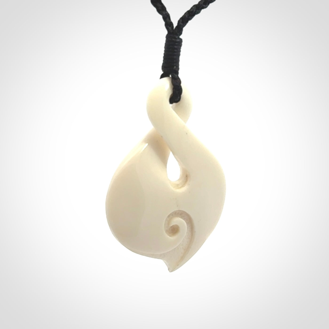 Hand carved bone twist pendant hand made by Peter Mitchell in New Zealand. This bone twist is provided with an adjustable black cord and packaged in a woven kete pouch.