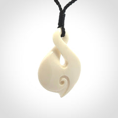 Hand carved bone twist pendant hand made by Peter Mitchell in New Zealand. This bone twist is provided with an adjustable black cord and packaged in a woven kete pouch.